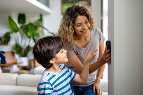 Mother and son adjusting thermostat